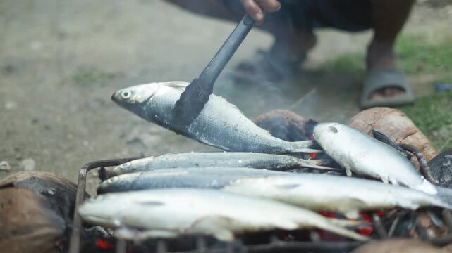 Close-up shots of grilled milkfish (bangus) cooked using dried coconut husk as fuel