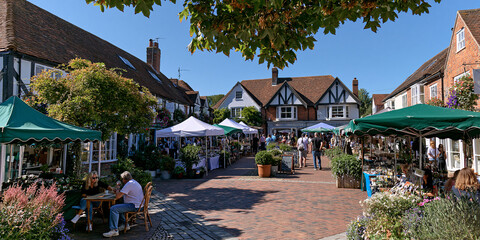 Obraz premium Bustling Farmers Market Square: Daytime Shopping and Leisure in a Colorful, Charming Outdoor Community