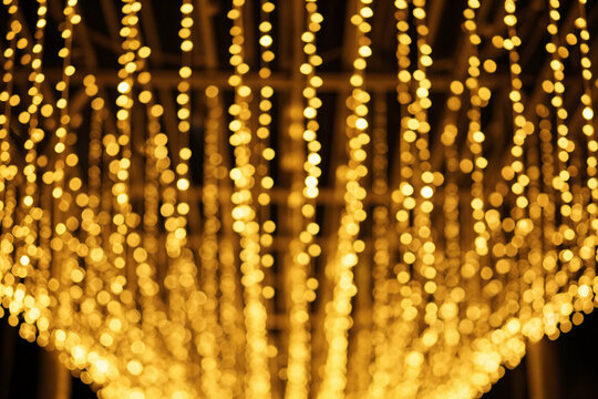 Golden lights cascade downward in radiant streaks. Blurred bokeh creates a warm, dreamlike glow.