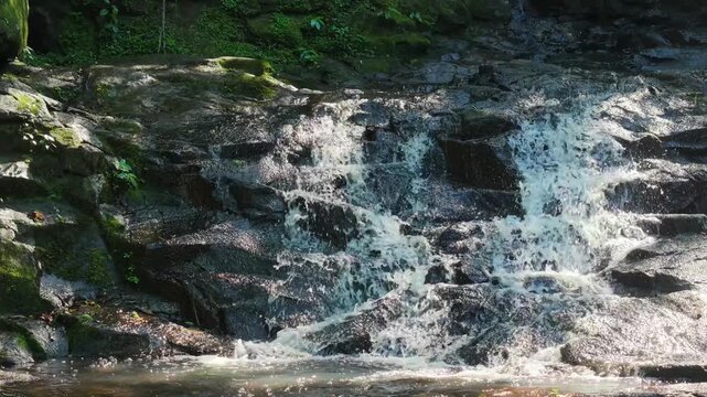 Salto Guatamb&uacute; Puerto Libertad Misiones Argentina with water cascading over layered basalt rock and mossy surface in subtropical forest, drone push in to extreme close up shot