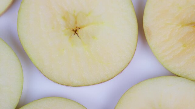 Apple slices displayed. Repeating apple pattern on white background suitable for various uses. Bright studio illuminated apple pieces with star shapes and fresh dew for marketing