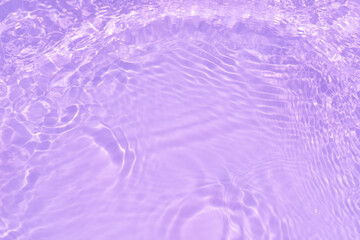 Pink water bubbles on the surface ripples. Defocus blurred transparent pink colored clear calm water surface texture with splash and bubbles. Water waves with shining pattern texture background