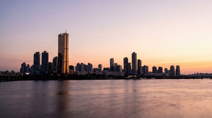 Obraz premium Stunning panoramic view of the Seoul skyline and the iconic 63 Building reflected in the Han River during a peaceful sunset in South Korea.