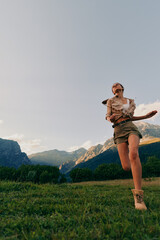 Fototapeta premium A carefree woman explores a sunny field with distant mountains, capturing a moment of outdoor living and joy. Concept includes freedom, nature, and healthy lifestyle.