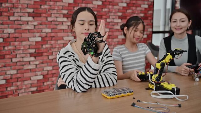 Female Teacher And Young Student Build Robotic Arm In STEM Science Class