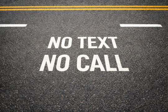 No text no call, road safety warning message on asphalt highway surface, traffic restriction concept, prohibition sign, driving awareness, transportation regulation, roadway communication, urban stree