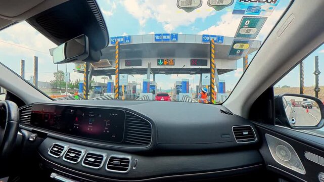 Car driving through a highway toll booth pov