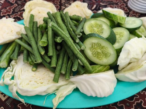 Fresh Mixed Vegetables on Turquoise Plate - Green Beans, Cucumber Slices and Cabbage, Healthy Raw Indonesian Lalapan Platter for Cooking and Food Photography