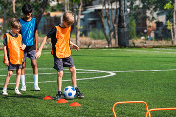 Fototapeta premium World cup concept with soccer ball or football player, youth soccer drill on green field with children practicing footwork and ball control