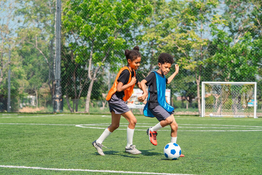 World cup concept with soccer or football player, youth soccer practice on green field with two children running after ball