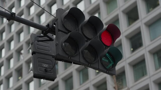 Closeup of urban traffic signal with red stop and green pedestrian arrow lights in Tokyo