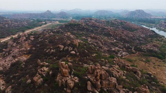 rocky terrain with Sahyadri Mountains, Tungabhadra river and Vitthal Mandirv at nimbapura, hampi, karnataka, india. day time, crane shot, drone shot, 4k.