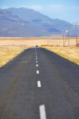Naklejka premium Landscape, empty and road with mountain for travel, tourist destination and journey outdoor. Nature, background and street with route, highway and space for vacation, trip and holiday with vehicle