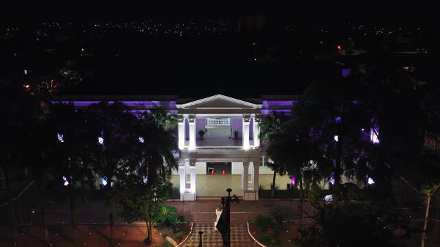 Establishing aerial shot of Municipality (City Hall) colonial building in Villarrica city center, surrounded by tress and Plaza de los H&eacute;roes