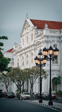 Ornate White Colonial Building with Street Lamps and Trees