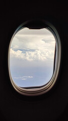 Fototapeta premium Cloud View from Airplane Window Above the Sky During Flight