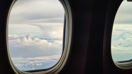 Fototapeta premium Cloud View from Airplane Window Above the Sky During Flight