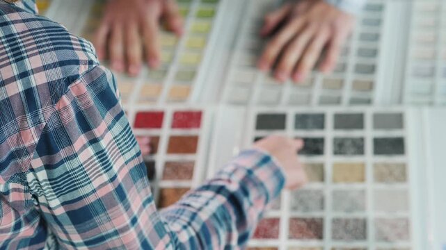 Woman selects color samples from material palette with hands, creating dynamic visual of choice process.
