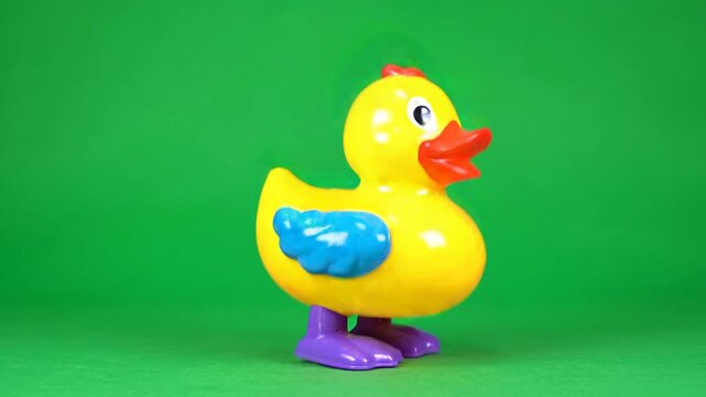 Rubber duck, yellow toy, blue wing, purple feet, green background ai 4k Video
