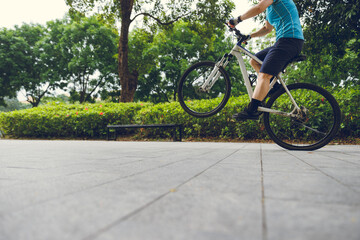 Naklejka premium People practice wheelie in the park