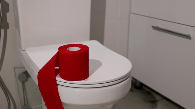 Woman placing red toilet paper on bathroom seat to symbolize hemorrhoid awareness and digestive health. Proctological disease prevention concept. Clinical hygiene care and intestinal cancer screening.