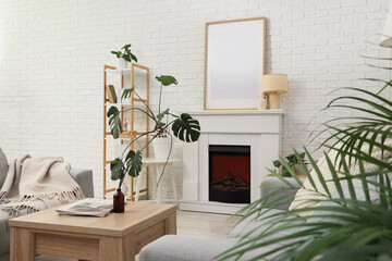 Naklejka premium Interior of living room with fireplace, table and blank poster