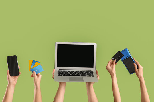 Female hands with credit cards, gadgets and payment terminal on green background. Online banking concept
