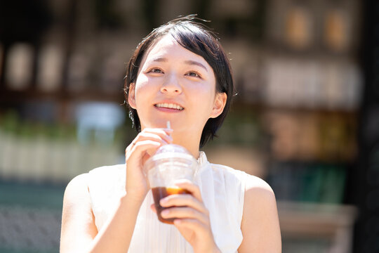 アイスコーヒーを持って笑っている女性