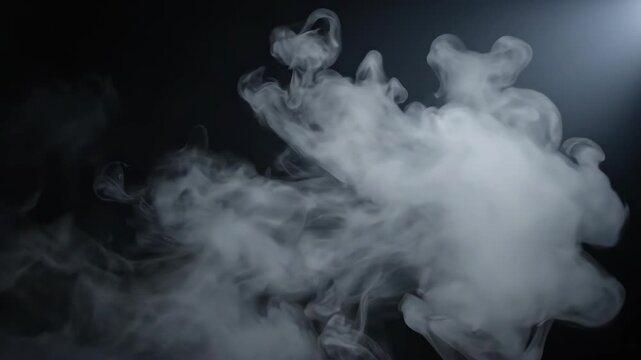 Dense white smoke swirls elegantly in a dark atmosphere, illuminated by a soft light source above