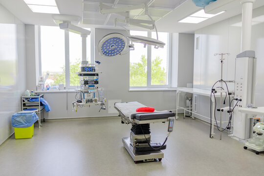 Modern empty operating room with surgical equipment and medical bed