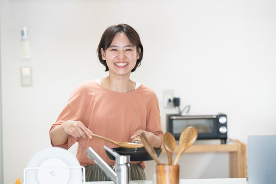キッチンで料理をしている笑顔の女性
