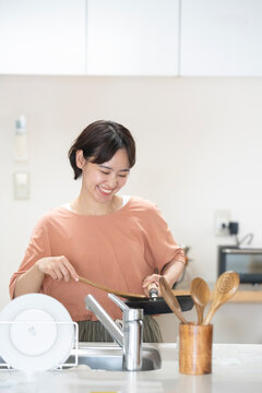 キッチンで料理をしている笑顔の女性