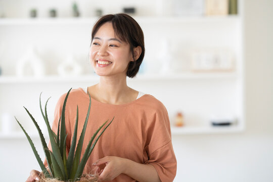 アロエの鉢を持っているショートカットの女性