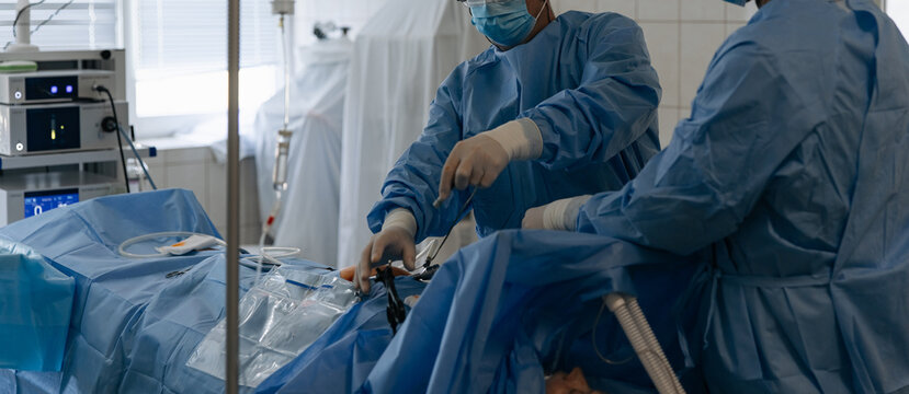 Surgeons performing laparoscopic abdominal surgery with endoscopic tools
