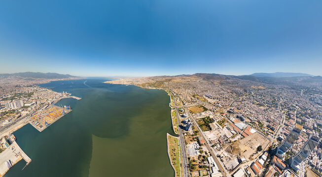 Izmir, Turkey. Panoramic view of Izmir Bay with modern Bayrakli shoreline. Kumsal beach, deniz merdivenleri, and rekreasyon alani with picnic areas and sosyal medya meydani. Summer day. Aerial view.