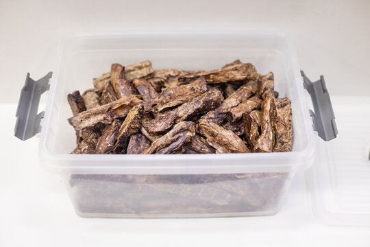 Container filled with dried treats for pets. Fish treats, storage box, pet snack, dried, store stock