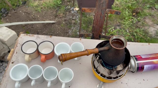 Brewing traditional Turkish coffee in a copper cezve on a camping stove.