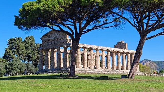 Ancient Greek Temple of Athena in Paestum, Italy at sunny day with blue sky. Famous archaeological site of Paestum, Magna Graecia, ancient ruins.