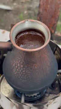 Brewing traditional Turkish coffee in a copper cezve on a camping stove.