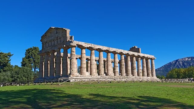 Ancient Greek Temple of Athena in Paestum, Italy at sunny day with blue sky. Famous archaeological site of Paestum, Magna Graecia, ancient ruins.