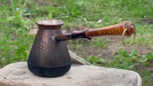 Brewing traditional Turkish coffee in a copper cezve on a camping stove.