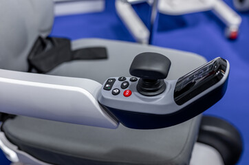 Hand control panel for electric wheelchair. joystick and buttons for controlling a wheelchair on a blurred background. selective focus © NastyaPhoto