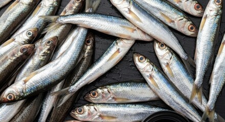 Obraz premium Close-up of multiple silvery fish on a dark, textured surface