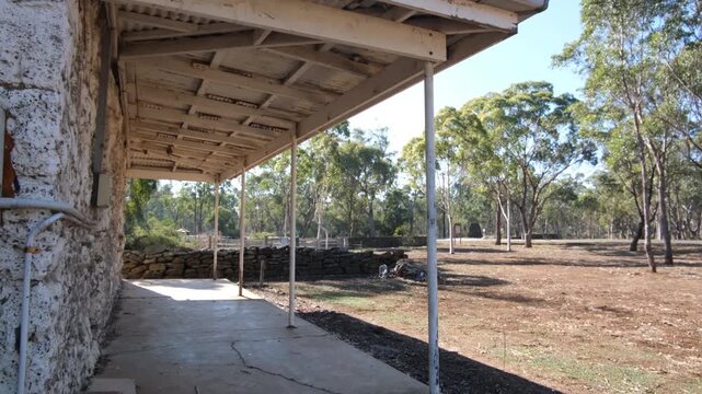Veranda of a rustic rural homestead in Eynesbury, Australia, overlooking dry Australian bushland with eucalyptus trees, open countryside. Traditional, historic rural architecture in regional Victoria
