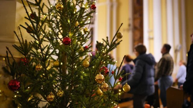 Christmas tree decorated with ornaments inside a Catholic Church during a service