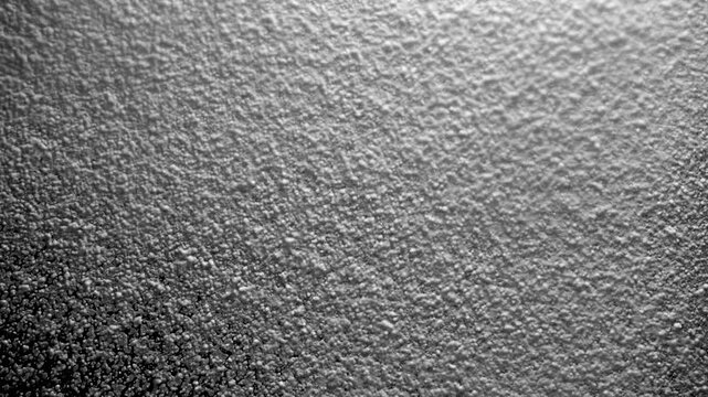 Dense spray of white foam and liquid droplets on a black background