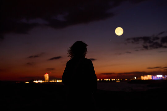 Woman observing stars, planets, Moon and other celestial objects.