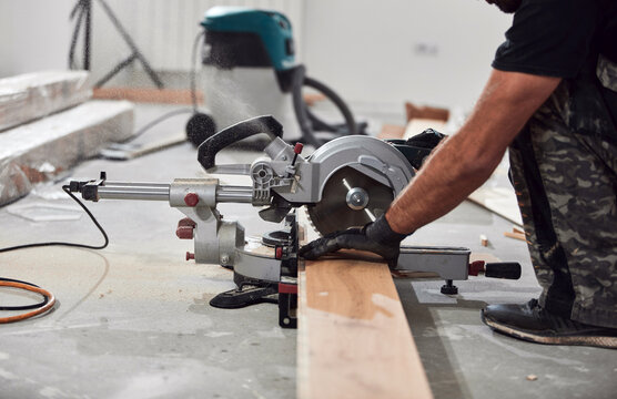 Professional handyman installing laminate flooring in a new apartment.