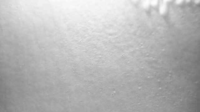 White foam flowing down a dark surface creating abstract patterns and textures