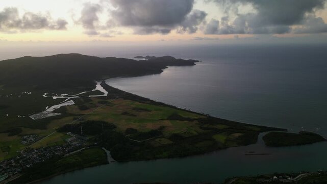 Stunning aerial drone shot of Cabugao Bay in Bato, Catanduanes, Philippines during sunrise with coastal landscape and dramatic clouds